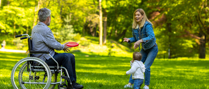 Parents and a cute kid playing frisbee and looking happy