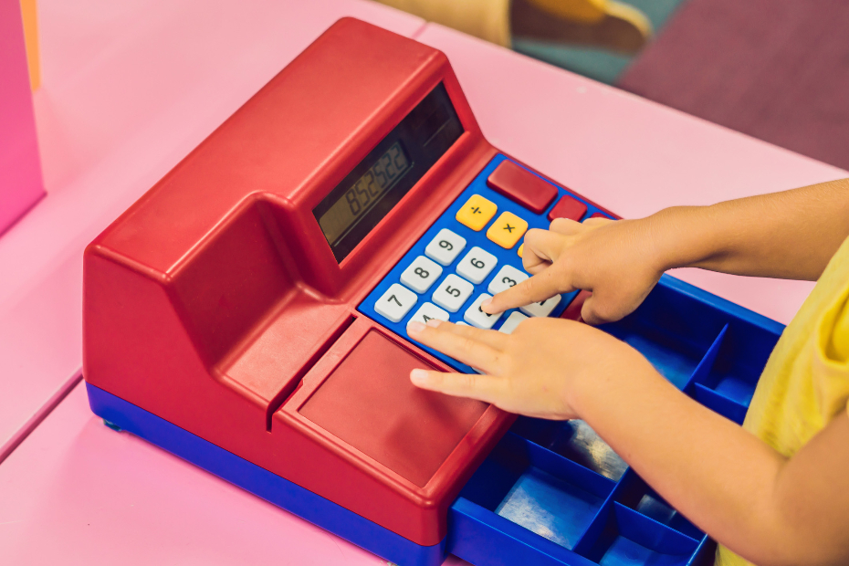 child playing with toy cash register