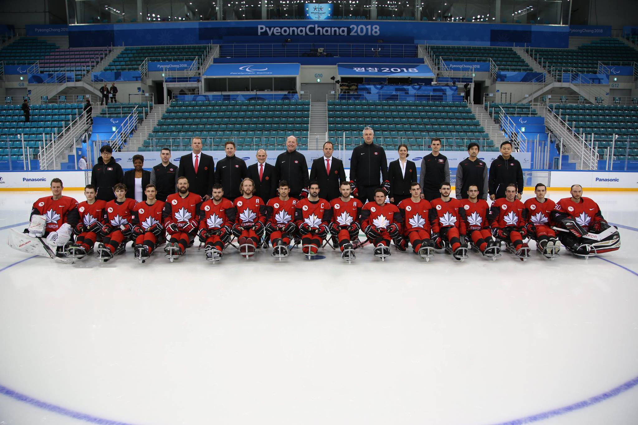 Team Canada posing in an ice rink at the 2018 Paralympic Games.