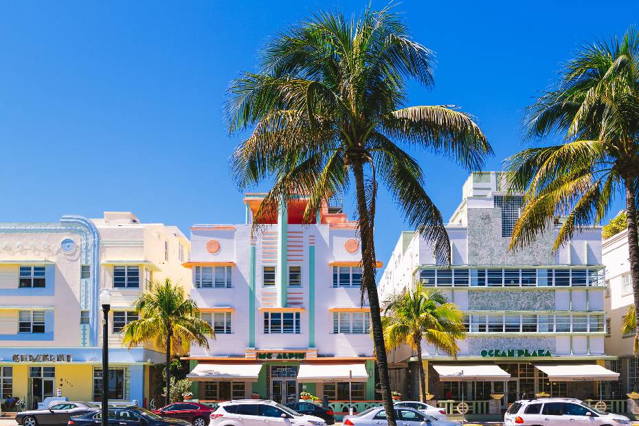 A row of colourful art deco Miami hotels with palm trees