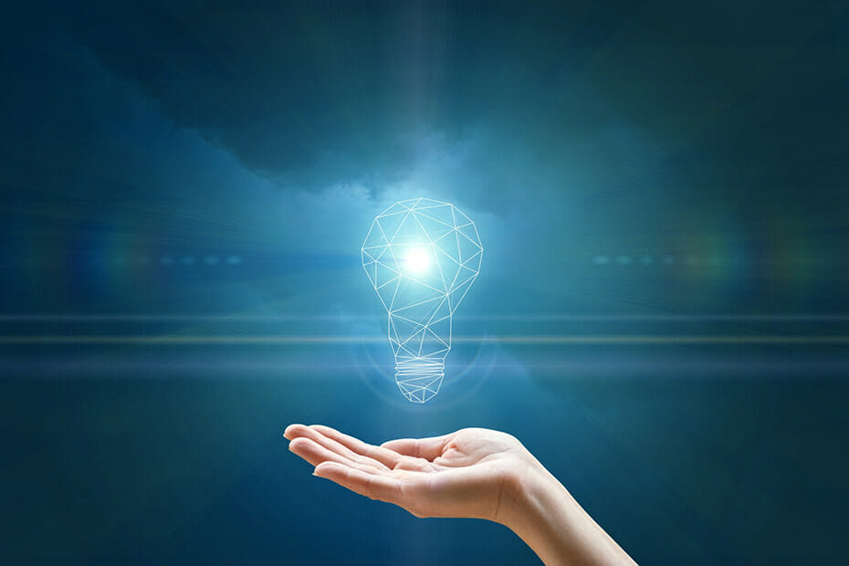 Black background with hand showing, holding a lit up light bulb - to represent a 