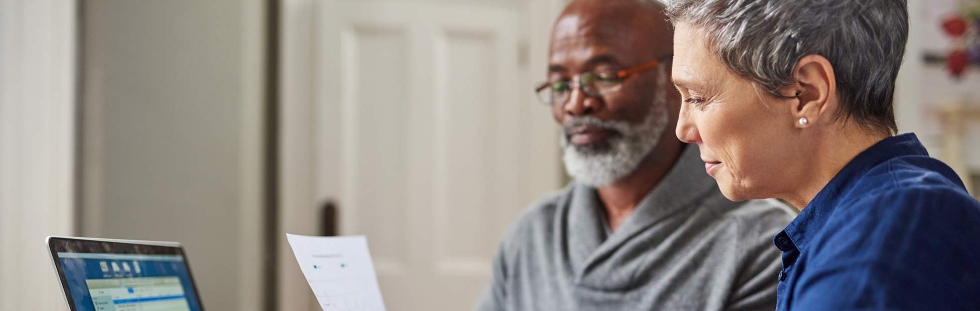 An elderly couple looking over financial documents together