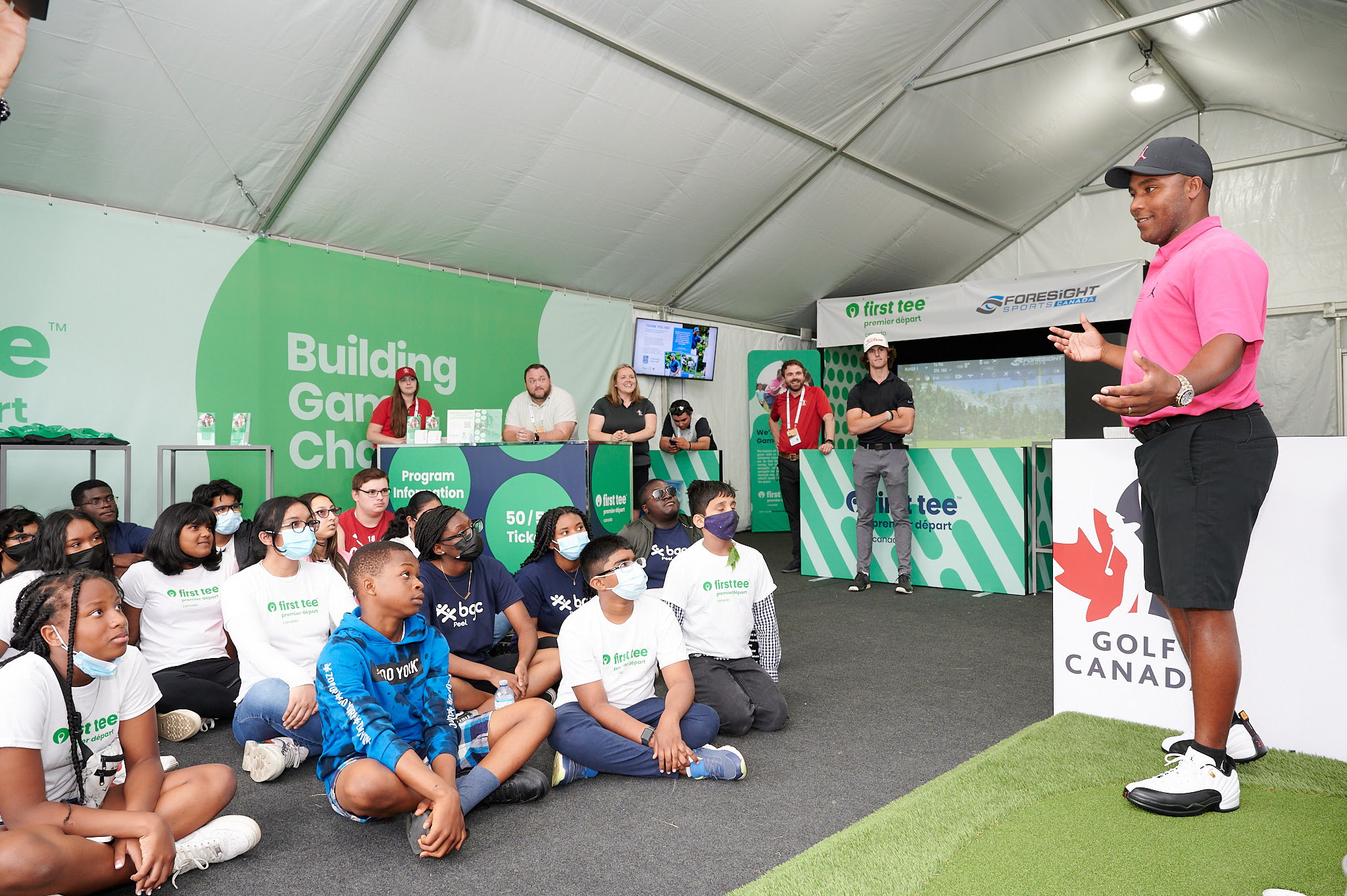 Pro golfer Harold Varner III speaking with youth participants in the First Tee tent